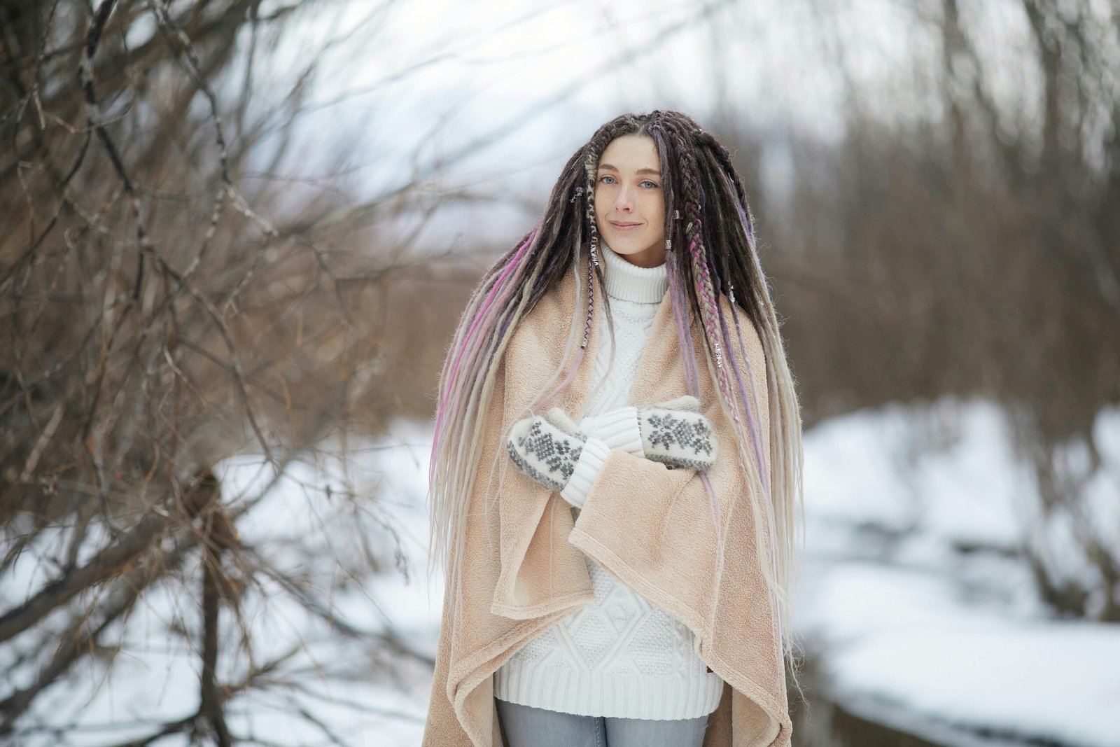 woman in pink long sleeve shirt and white skirt standing on snow covered ground during daytime